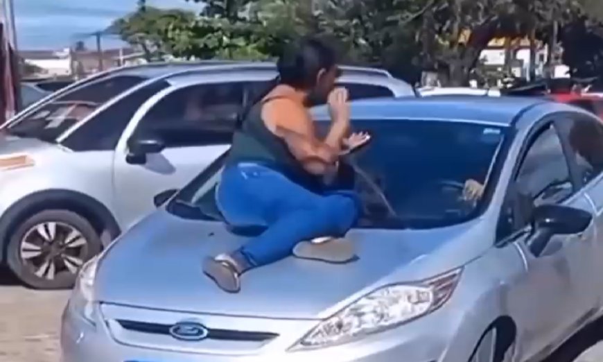 VÍDEO: Mulher traída flagra marido com amante e sobe no capô de carro em movimento e vídeo viraliza; Confira